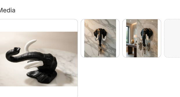 Black elephant trunk wall-mounted key holder with white tusk accents shown as standalone sculpture and mounted on marble wall holding keys